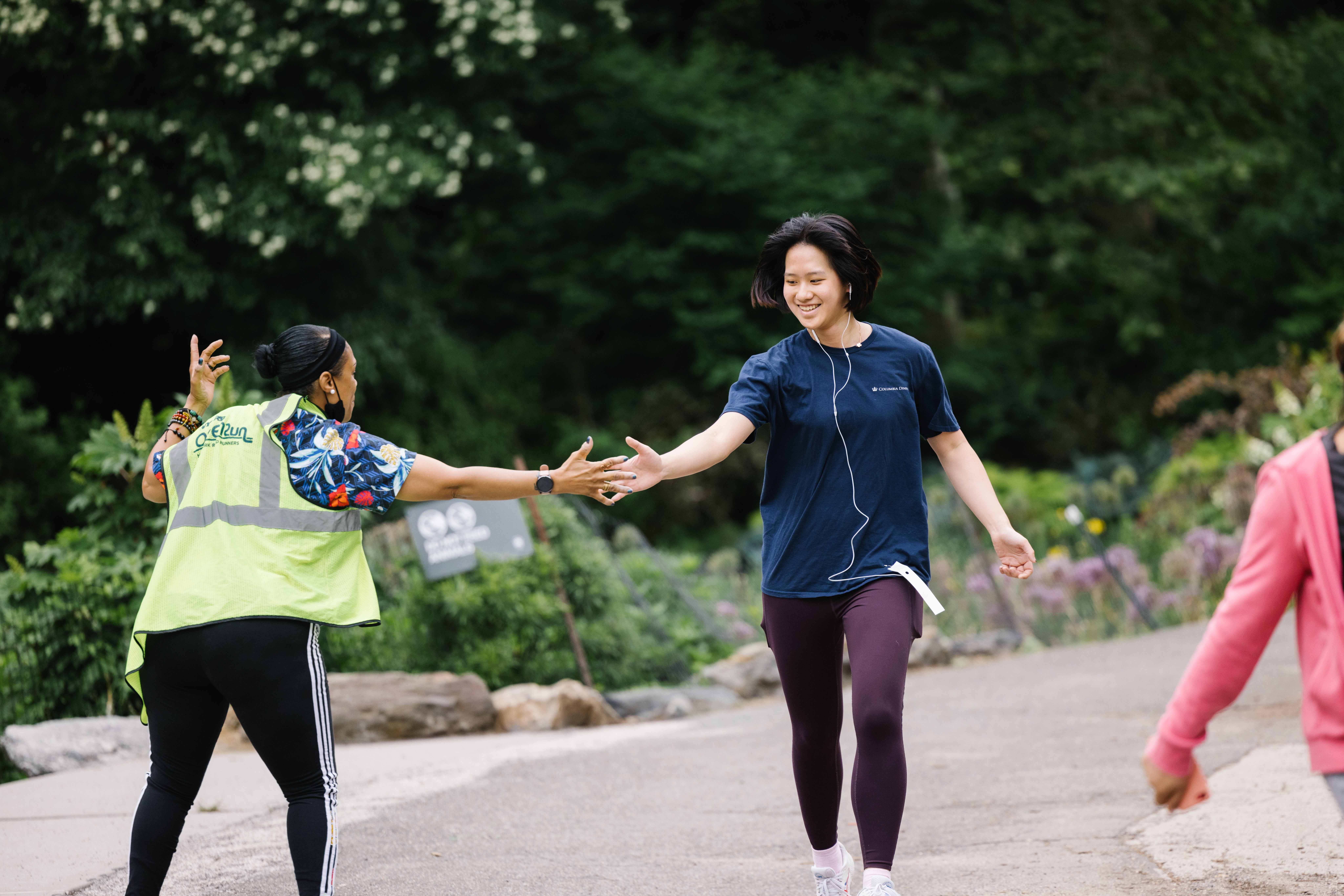 A runner high fives an Open Run volunteer